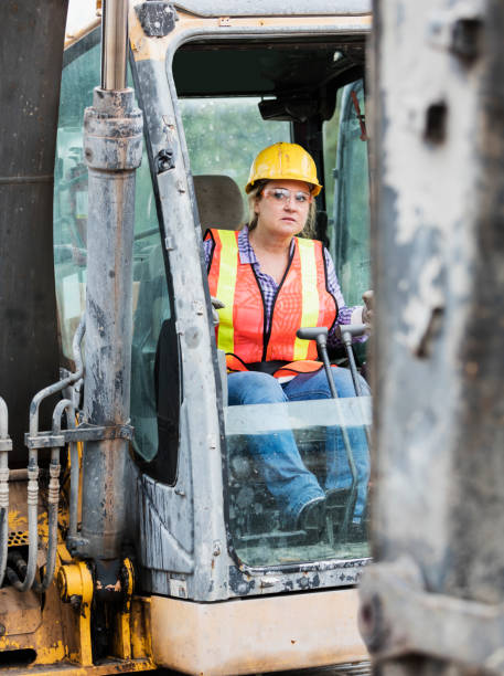 istock Hispanic female construction worker driving earth mover 1298023513