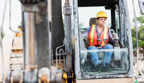 istock Hispanic female construction worker driving earth mover 1298023514