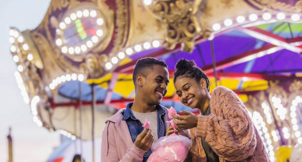 istock Young couple at carnival eating cotton candy 1298023564