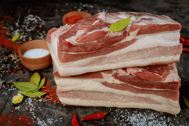 istock Raw pork belly with spices on dark background. 1298023597