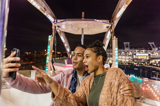 Young African-American couple riding ferris wheel
