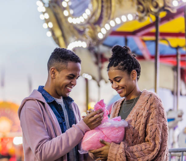 istock Young couple at carnival eating cotton candy 1298023623