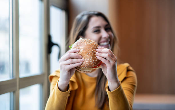 istock Young woman enjoys in burger. 1298024325