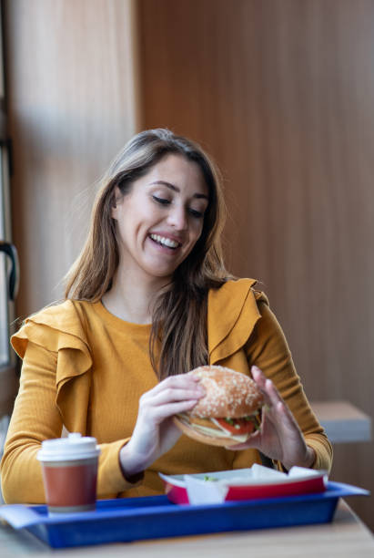 istock Young woman sitting in fast food restaurant. 1298024405