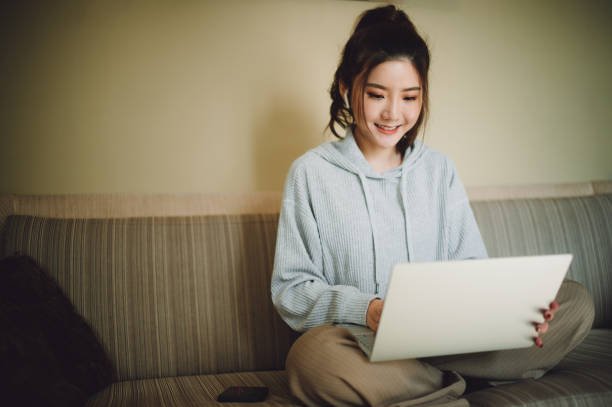 istock Young Asian woman working at home with her computer. 1298024641
