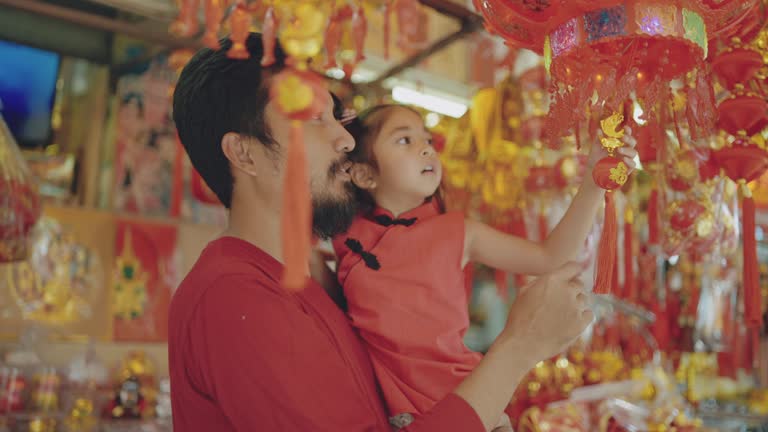 Asian family for shopping to decorate house with chinese new year ornaments to celebrate in chinese festival.