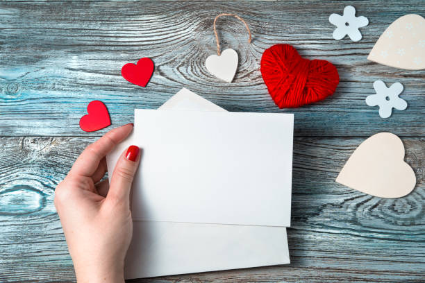 istock A woman in her hand holds an empty letter on a romantic background 1298026428