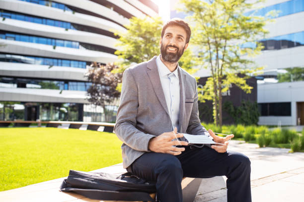 istock Businessman puts a protective mask on his face 1298026433