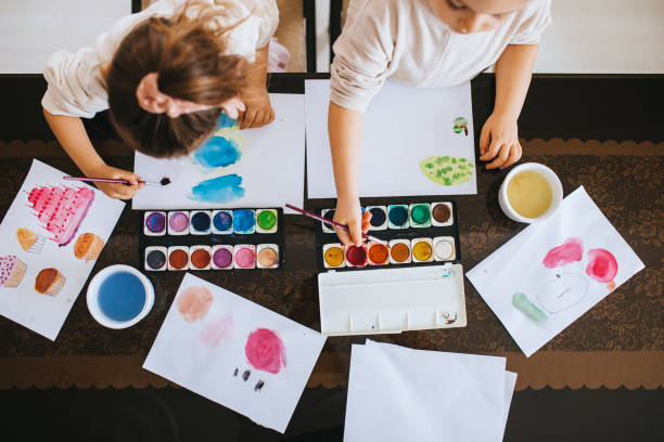istock Sisters having fun with watercolor paints at home 1298027038