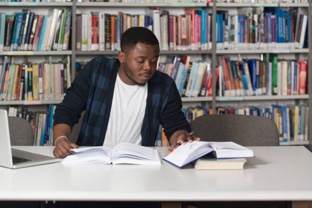 istock Happy African Male Student With Laptop In Library 1298037177
