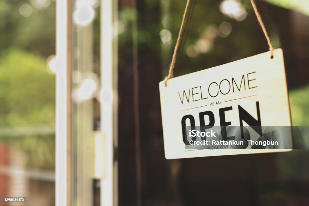 A business sign that says "u2018Open"u2019 on cafe or restaurant hang on door at entrance. Vintage color tone style. Open Sign Stock Photo