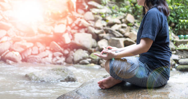 meditieren yoga hände der frau meditation in der natur wasserfall und linse flair effekt. gesundheitswesen, lifestyle-konzept. internationaler tag des yoga-bewusstseins - 40 weeks stock-fotos und bilder