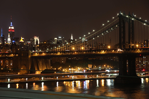Manhattan skyline seen at night from the Brooklyn Bridge across the East River