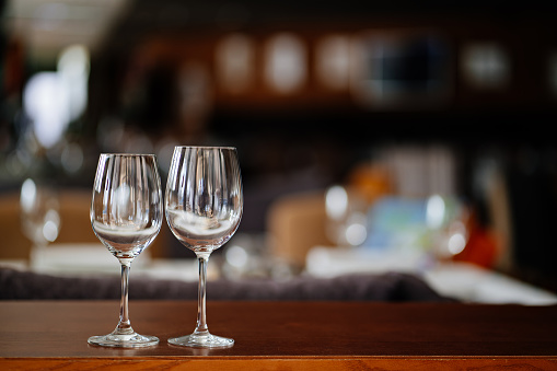 two empty clean wine glasses on a wooden table. utensils for alcoholic beverages. serving the table.