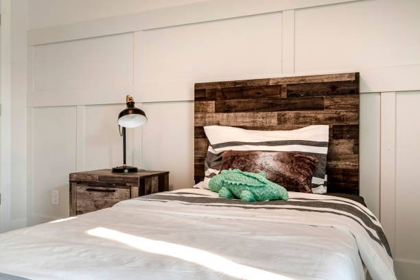 istock Single bed with brown wooden headboard and side table with modern lamp 1298057868