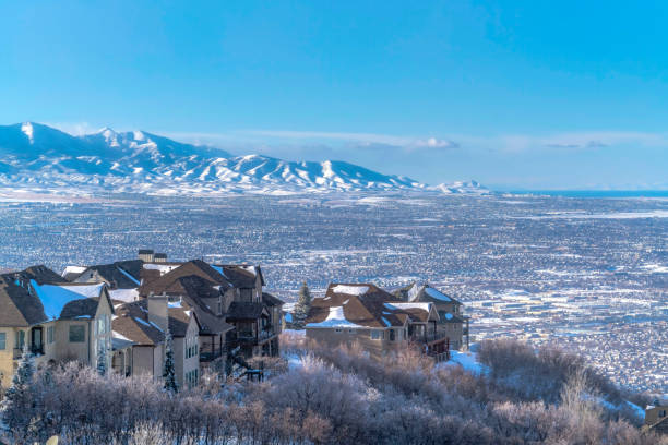 istock Snow falling on Wasatch Mountains with homes on frosted terrain in winter 1298057876