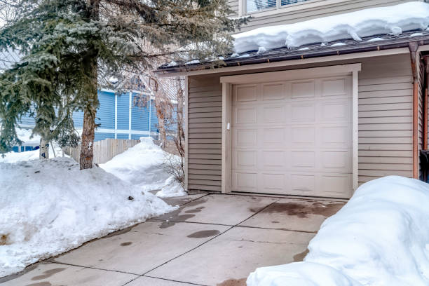 entrada da porta da garagem branca de casa com telhado coberto de neve e quintal no inverno - snow house color image horizontal - fotografias e filmes do acervo