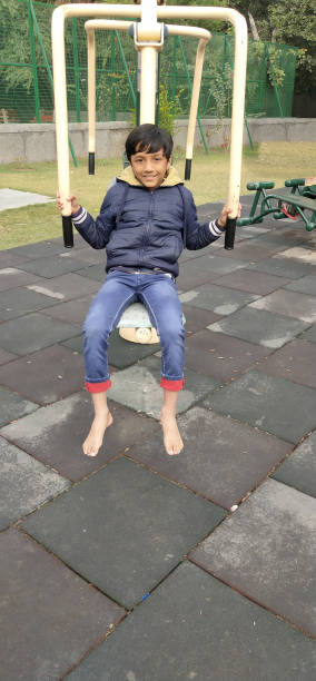 This young boy from India is enjoying the playground equipment and open spaces to practice some yoga and stretching, as well as just playing around and having a good time on this beautiful day.