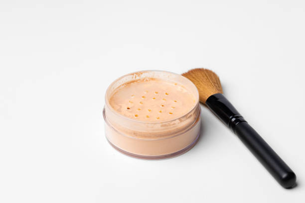 istock Decorative cosmetics face powder and brush close up 1298067083