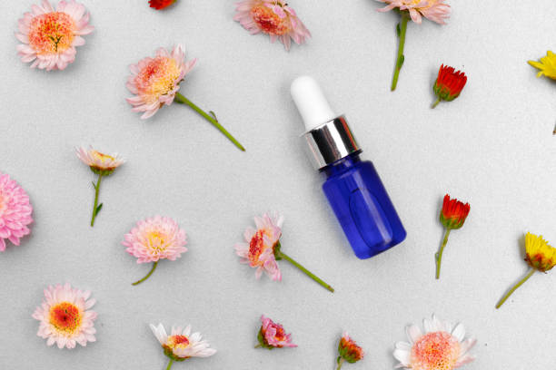 istock Cosmetic oil bottle on floral buds background 1298069406