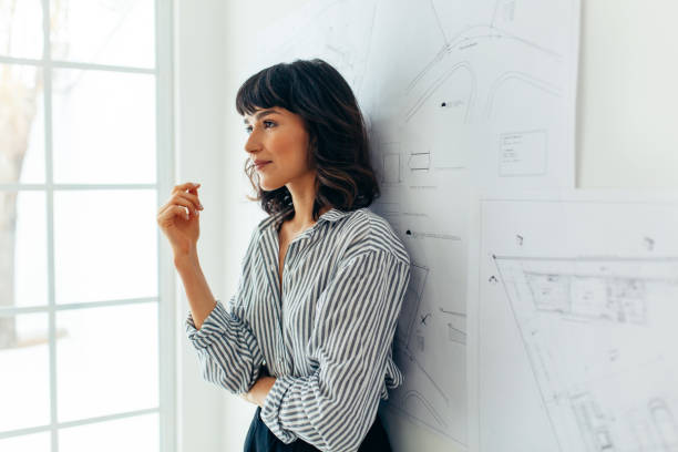 istock Confident female architect standing near drawings 1298074181