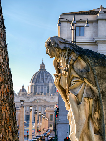 Rome, Italy, January 08 -- The statue of St. Catherine of Siena and a decreasing perspective of Via della Conciliazione and St. Peter's Basilica in Rome. The Basilica is the center of the Catholic religion, one of the most visited places in the world and in Rome for its immense artistic and architectural treasures. Photo in high definition format.