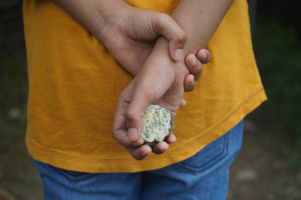 istock A child holds a stone. bullly concept 1298074939