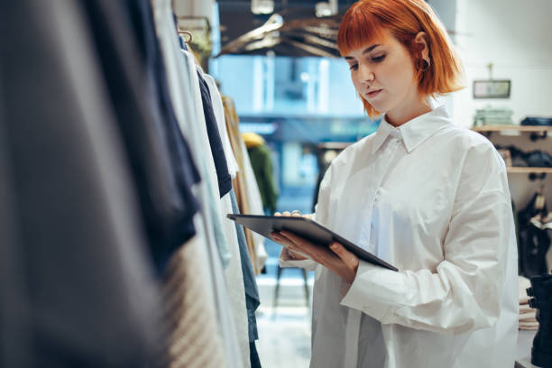 istock Female entrepreneur using digital tablet in her clothing store 1298077284