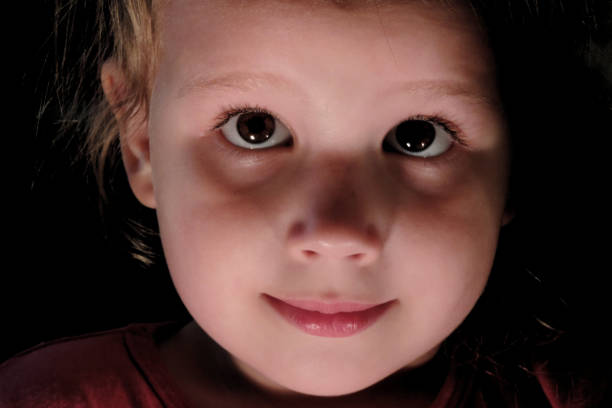 istock child's face close up in the dark 1298077308