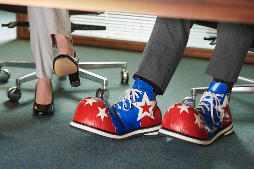 business colleague with clown shoes on in meeting