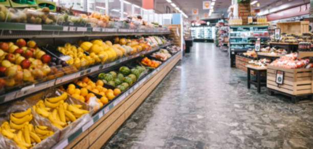 Produce aisle in supermarket Fully stocked aisles in a grocery store. Assorted fruits and vegetables on racks in supermarket. produce section stock pictures, royalty-free photos & images