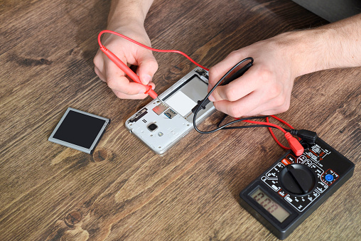 Phone repair concept. Checking with a multimeter