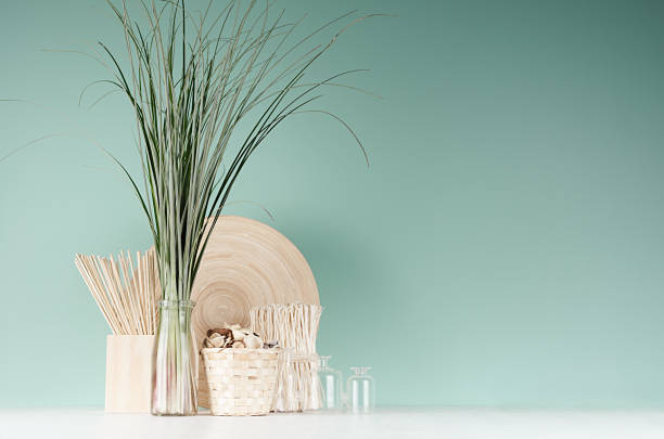 istock Natural soft light accessories for home decor - dried plant, wicker basket, sticks, bamboo plate, bouquet of reed, glass bottle in green mint menthe interior on white wood table. 1298079820