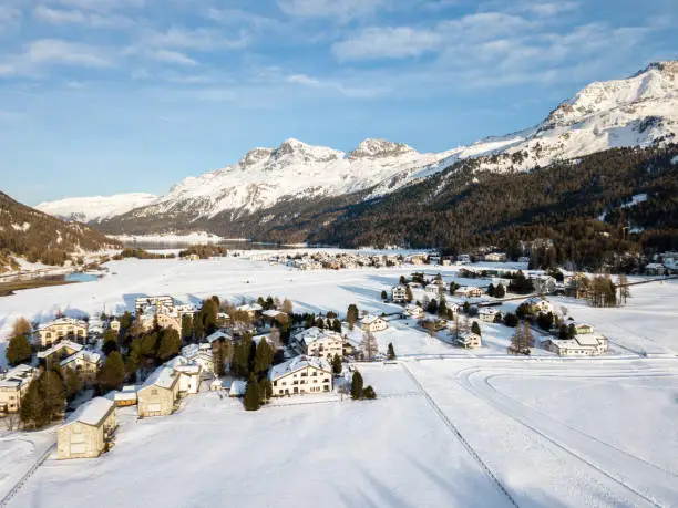 Aerial image of the Swiss Alps village Sils Maria or Segl Maria with Piz Corvatsch in the afternoon sun above. It is a famous creation resort in the St. Moritz region