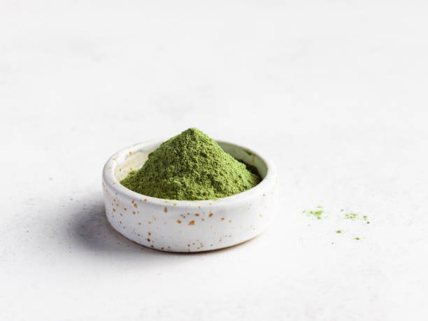 Green superfood powder in small bowl Green superfood powder in small bowl. Wheat grass, barley grass, chlorella, spirulina, maca powder. daily serving of vitamins and minerals. close-up. selective focus green tea powder stock pictures, royalty-free photos & images