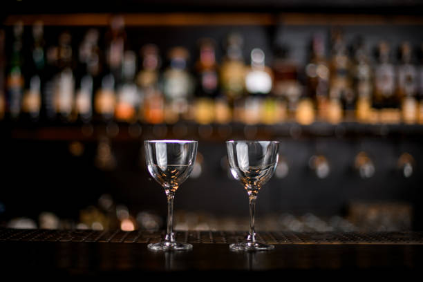 istock two beautiful transparent glasses with liquid stands on the bar counter. 1298083899