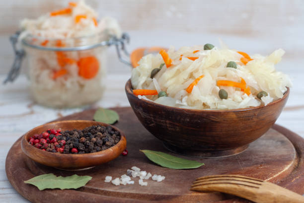 Homemade sauerkraut and fermented carrot in wooden bowl stock photo