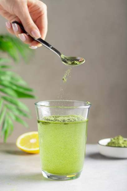 woman preparing drink with green superfood powder. immunity support