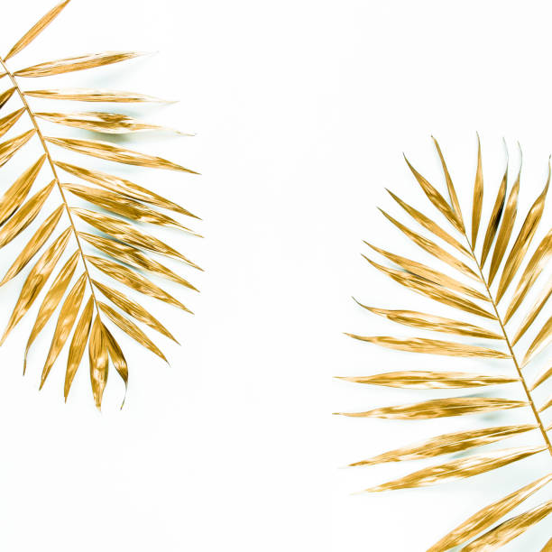 istock Gold tropical palm leaves on white background. Flat lay, top view minimal concept 1298085332