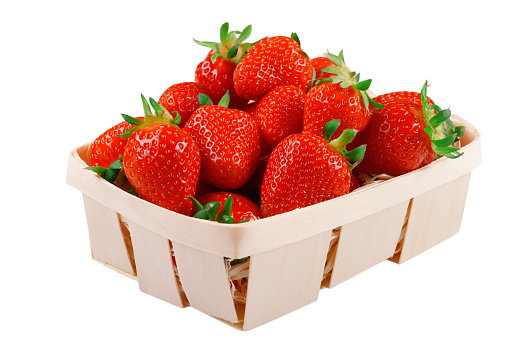 Fresh ripe red strawberries in a wooden basket on a white isolated background.