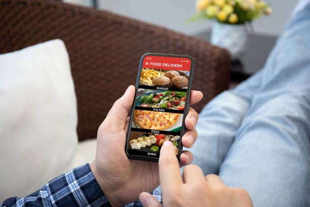 istock Man hands hold phone with food delivery application on screen 1298088262