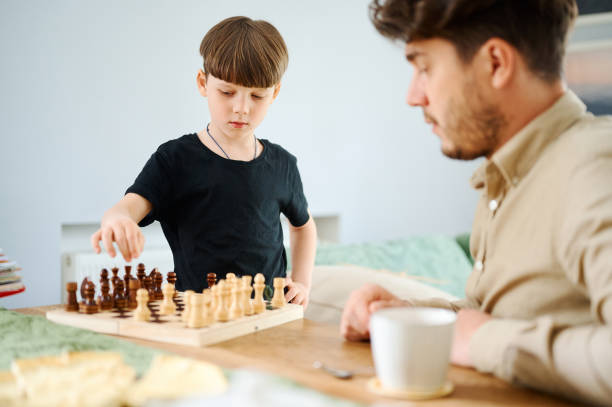 istock Father teaching son how to play chess. Concept of education and teaching. 1298090424