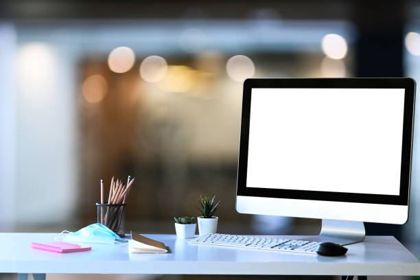 istock Creative designer workplace with computer, paper work, stationery and protective mask on white table. 1298092799