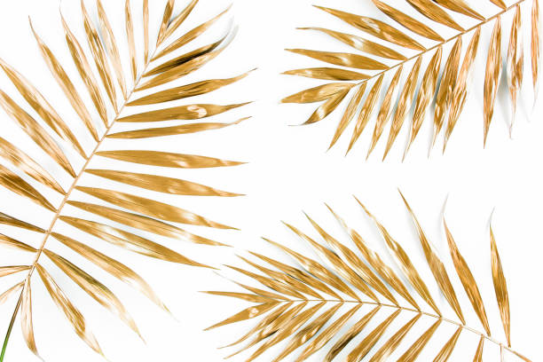 istock Gold tropical palm leaves on white background. Flat lay, top view minimal concept 1298092874