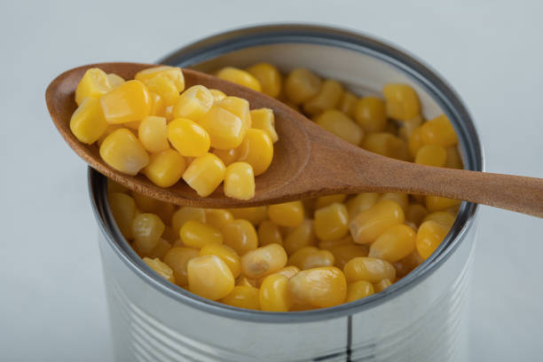 istock A wooden spoon full of popcorn seeds on a white background 1298093949