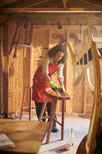 a small business owner recycling furniture from her garden workshop