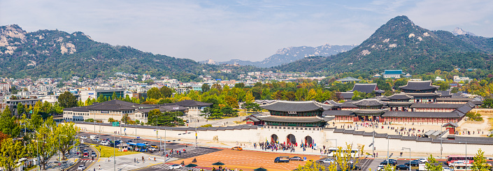Aerial panorama over the entrance to Gyeongbokgung Palace overlooked by mountains in the heart of Seoul, South Korea’s vibrant capital city.