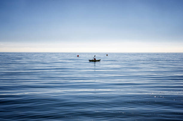 Turquoise fishing boat on the beach with sea and sky background.