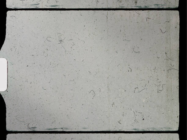 istock empty or blank 8mm film frame with black border and dust. 1298096663