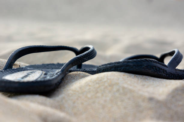 Sandals on the background of yellow sand. Summer. Relaxation. Background